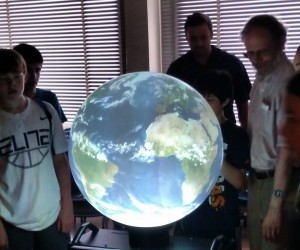 Glenn Flierl (far right) teaches a group of middle school students about ocean plastics using the iGlobe. (Photo Courtesy of John Marshall)