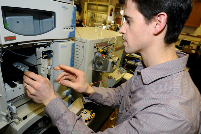 In the lab at WHOI, David Griffith analyzes samples of seawater he collected in Massachusetts Bay to detect minute quantities of estrogens in the ocean. (Photo by Ken Kostel, Woods Hole Oceanographic Institution)